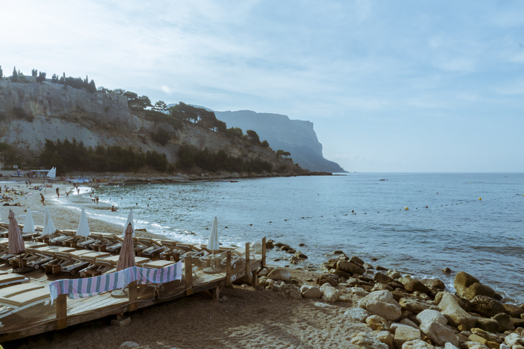 La plage de la Grande Mer à Cassis par un matin d'été avec le Cap Canaille en fond.