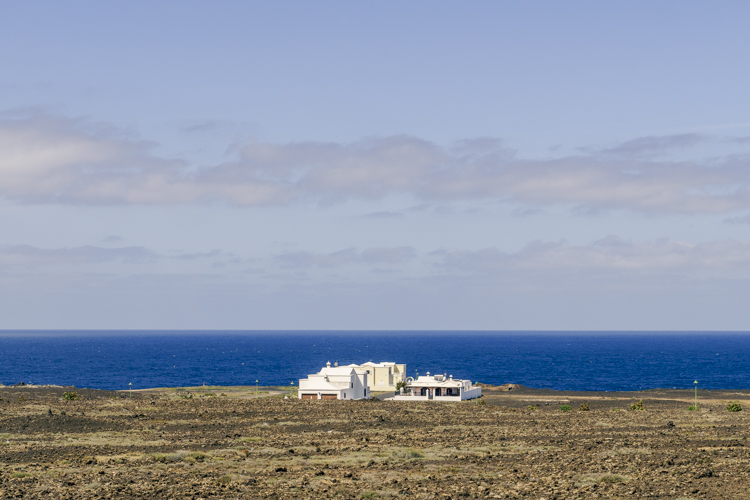 Trois villas au milieu d'une plaine désertique au bord de l'océan Atlantique.