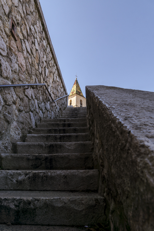 Le clocher de l'église Saint Sébastien à Allauch dans la continuité d'un escalier.