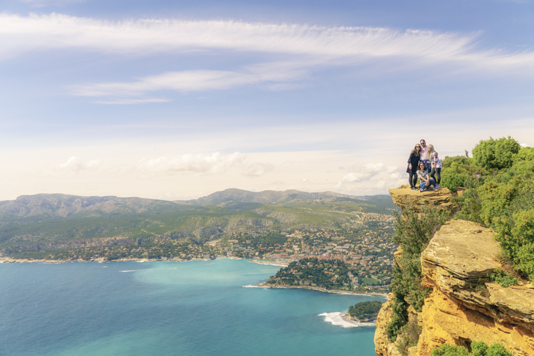 Une groupe de 4 touristes posant pour la photo tout au bord d'une falaise de 399 mètres de haut.