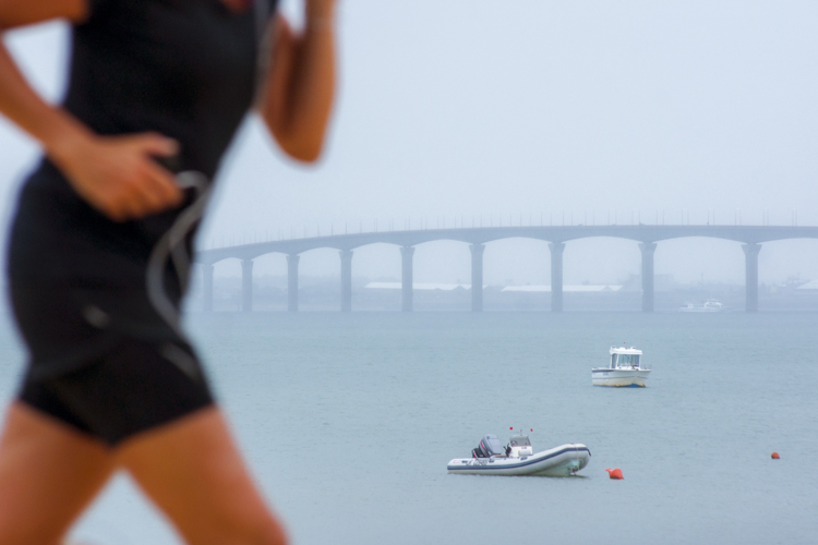 Le pont reliant l'Ile de R� au continent en arri�re plan avec un joggeur au tout premier plan.